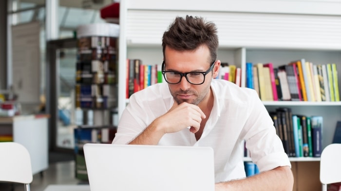 man reading on a laptop